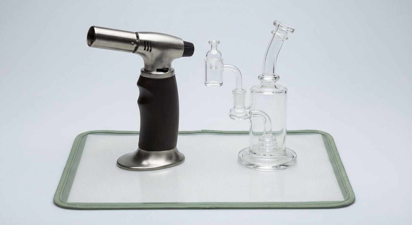 Close-up of a clean butane dab torch next to a dab rig on a silicone dab mat