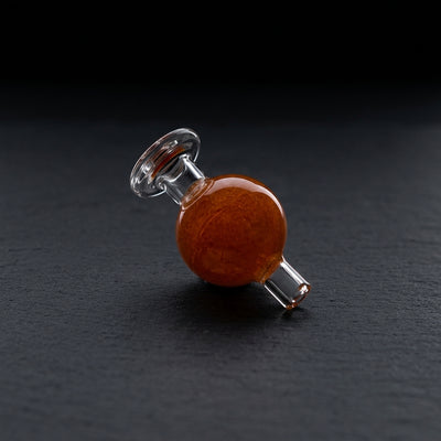 1.5″ ORANGE BALL CARB CAP on dark slate surface - Oil Slick Pad