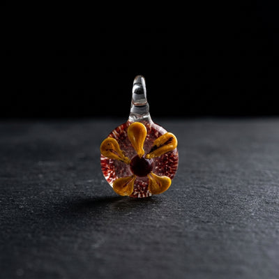 1.5" Yellow Flower Pendant on dark slate surface - Oil Slick Pad
