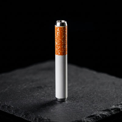 2'' Metal Cigarette Chillum - 1 on dark slate surface - Oil Slick Pad
