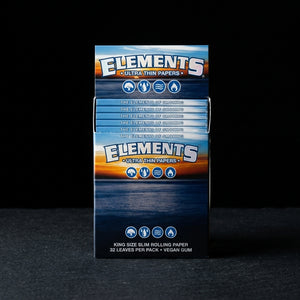 Elements King Size Slim Rolling Papers on dark slate surface - Oil Slick Pad