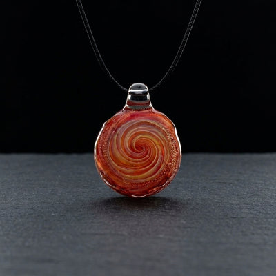 2" Red Spiral Pendant on dark slate surface - Oil Slick Pad