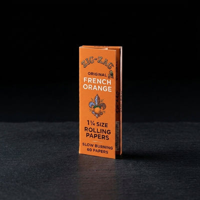 Zig Zag 1 ¼ French Orange Rolling Papers on dark slate surface - Oil Slick Pad
