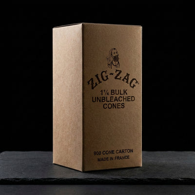Zig Zag 1 ¼ Bulk Unbleached Cones - (900 Cone Carton) on dark slate surface - Oil Slick Pad
