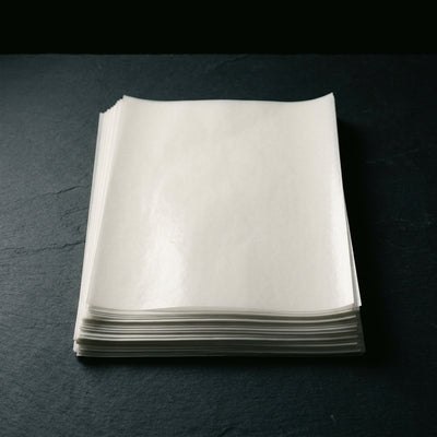 Oil Slick Paper - Editorial product shot, neat stack viewed from above on matte slate