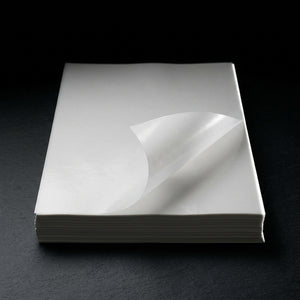 Oil Slick Paper - Editorial product shot, single sheet with curled corner showing thickness